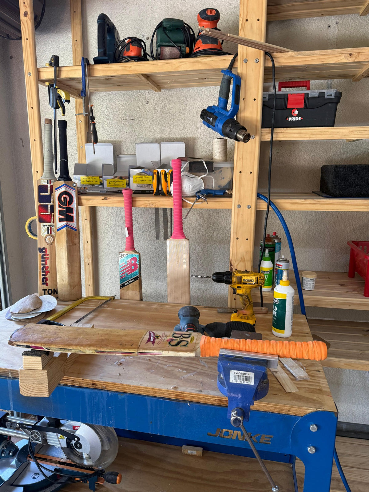 Liam's 2nd Innings workshop with cricket bat clamped on repair bench and specialist tools